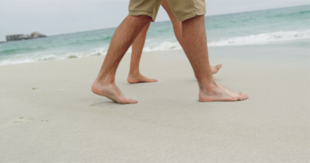 Barefoot Couple Walking on Sandy Beach Enjoying Ocean Views