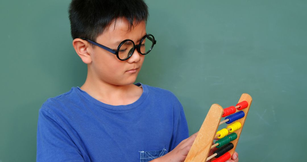 Schoolboy Using Abacus in Classroom for Math Learning