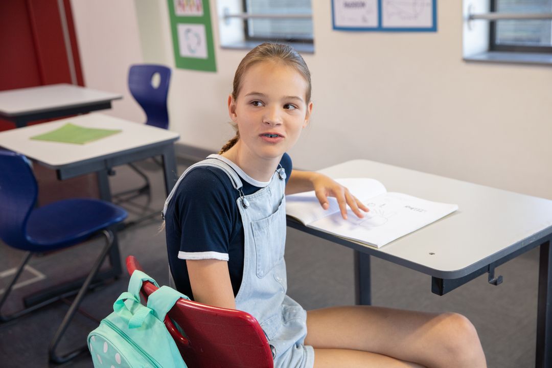 Teenage Girl Engaged in Class with Book in Casual Outfit