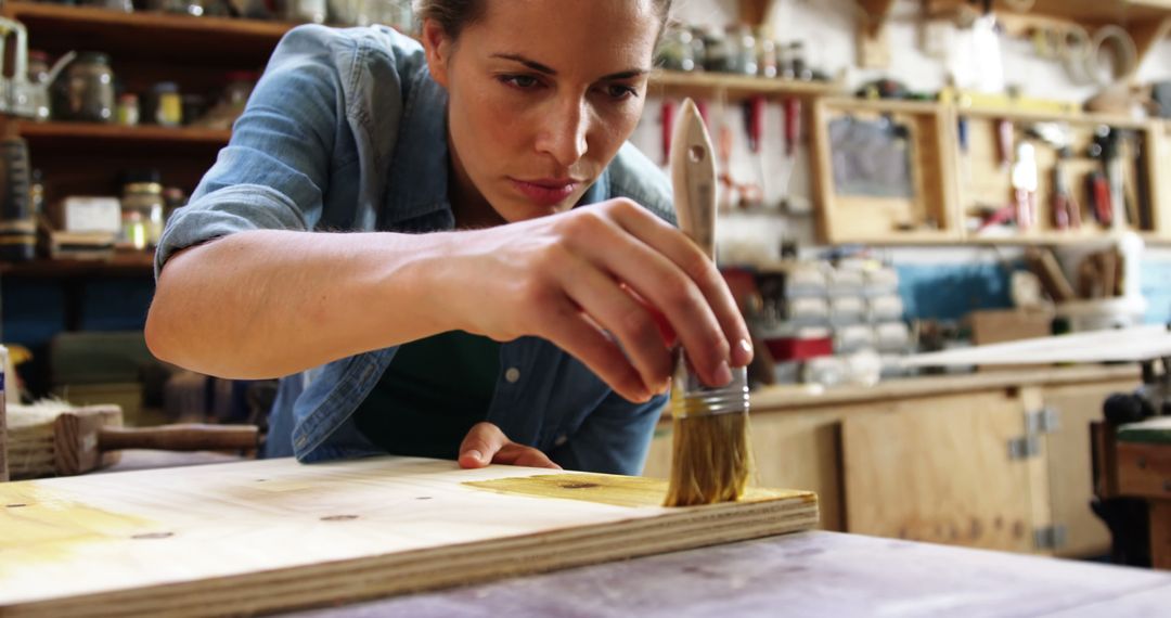 Young Woman Painting Wood in Workshop - Free Images, Stock Photos and Pictures on Pikwizard.com