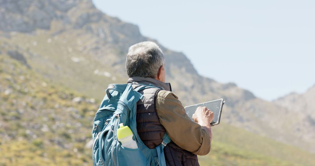 Senior Man Hiking with Tablet in Mountainous Landscape - Free Images, Stock Photos and Pictures on Pikwizard.com