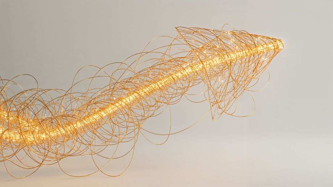 Abstract golden wire curved arrow sculpture with luminous glow