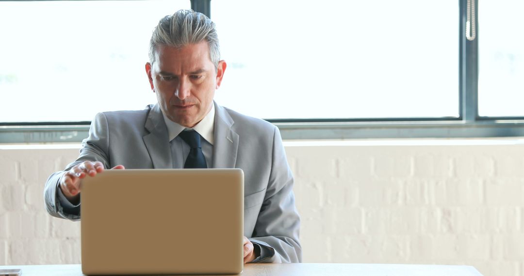 Professional Male Businessman Working on Laptop in Office - Free Images, Stock Photos and Pictures on Pikwizard.com