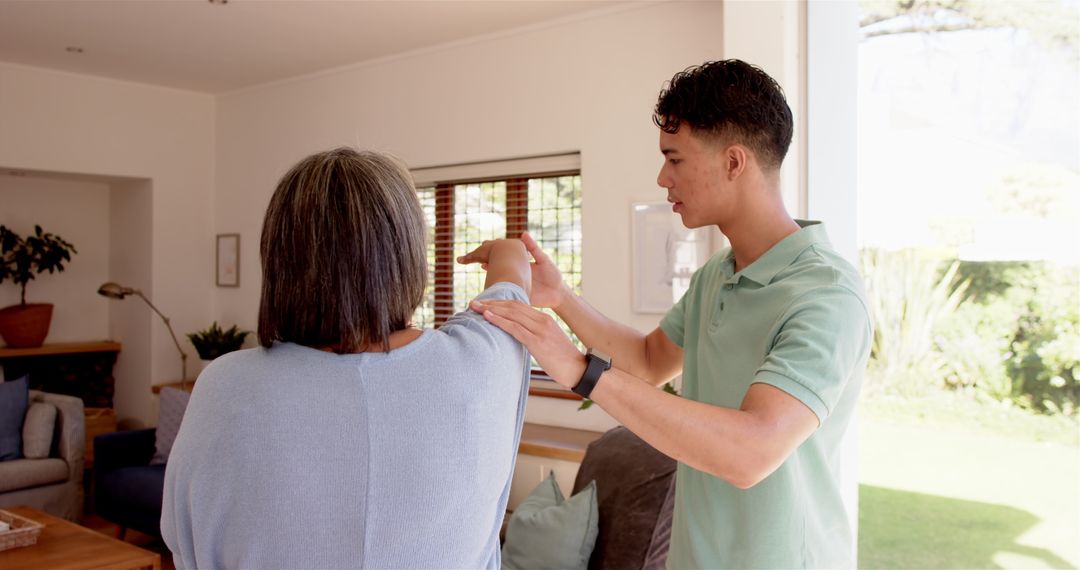 Young Physiotherapist Assisting Senior with Shoulder Exercise