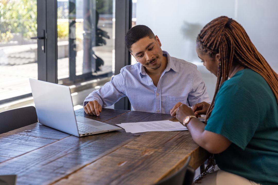 Diverse Professionals Analyzing Document in Modern Office Workspace