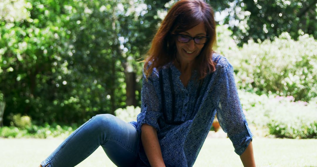 Smiling Woman Sitting on Grass in a Park - Free Images, Stock Photos and Pictures on Pikwizard.com