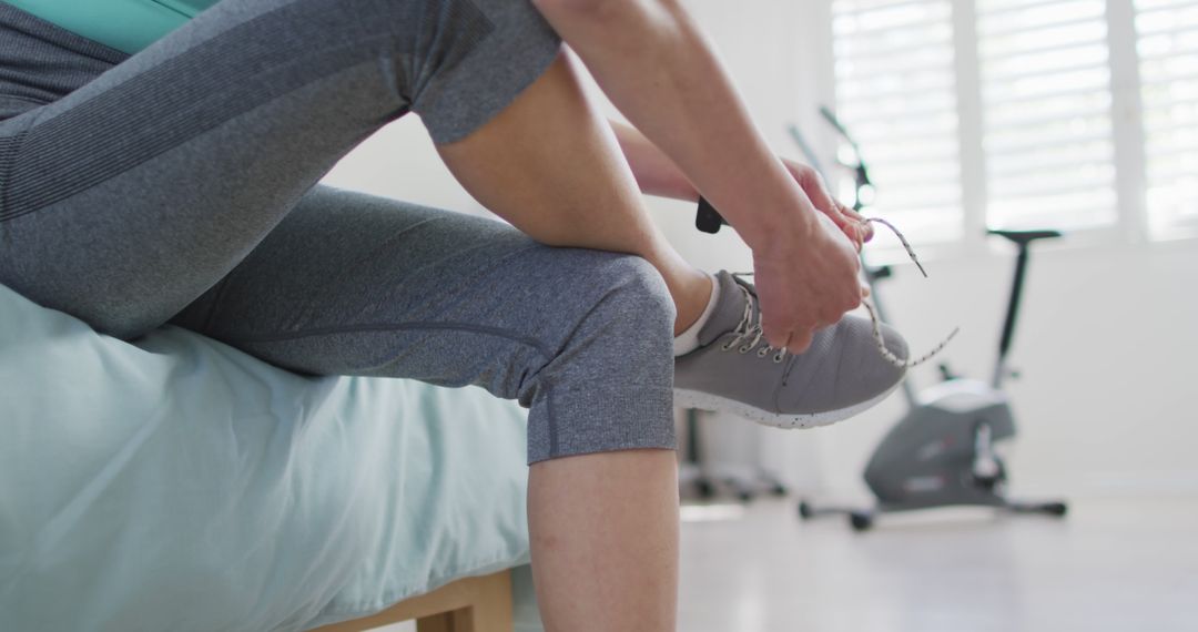 Person Preparing for Workout by Tying Sneakers Indoors - Free Images, Stock Photos and Pictures on Pikwizard.com