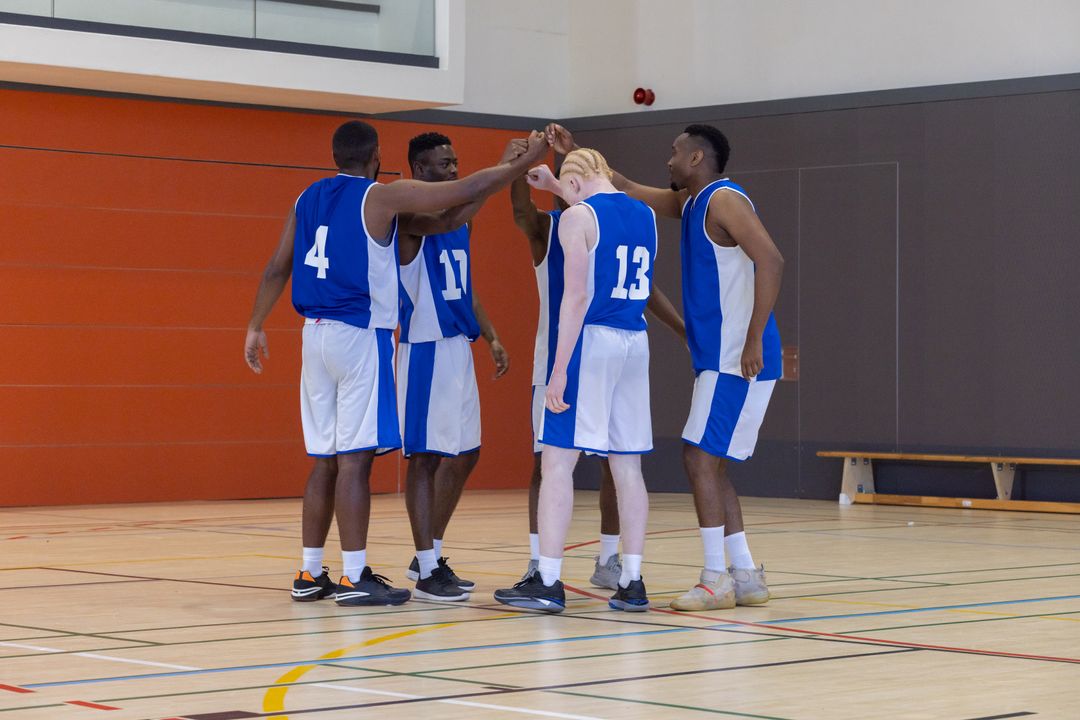 Diverse Basketball Team Huddling in Unity on Indoor Court
