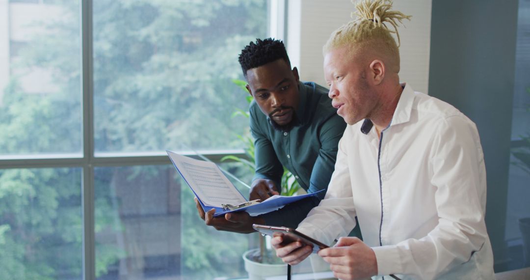 Diverse Businessmen Analyzing Documents in Modern Office Setting