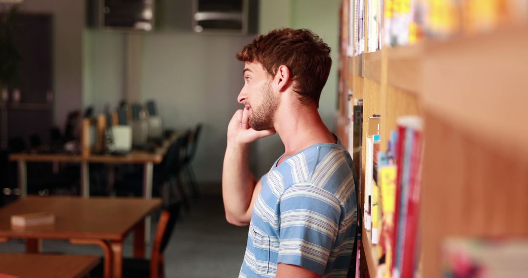 Young Man Talking on Phone in Library - Free Images, Stock Photos and Pictures on Pikwizard.com