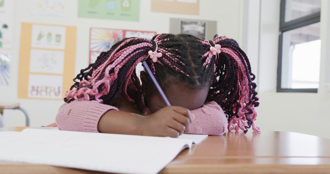 Young Schoolgirl in Classroom with Pencil and Notebook