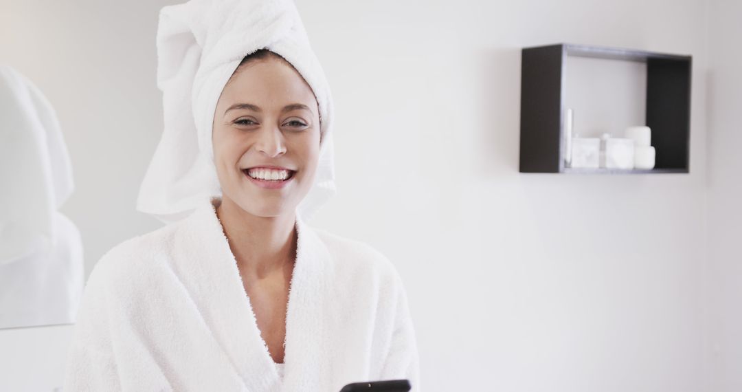 Happy Woman in Towel Robe Using Smartphone in Modern Bathroom - Free Images, Stock Photos and Pictures on Pikwizard.com