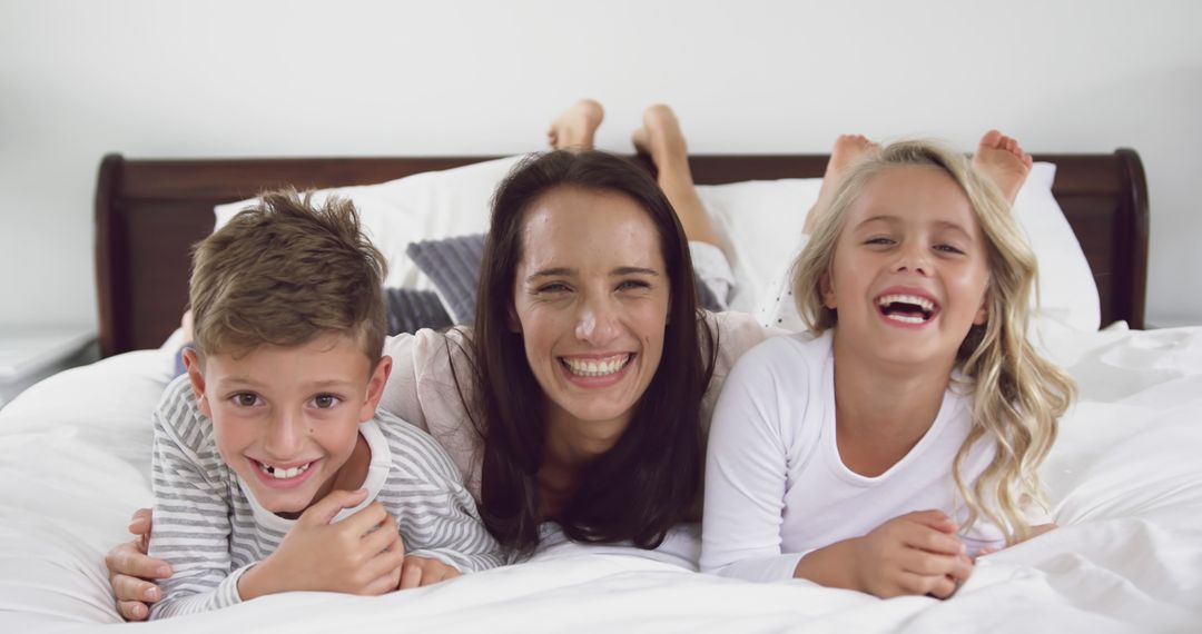 Happy Family Laughing Together in Bed - Free Images, Stock Photos and Pictures on Pikwizard.com