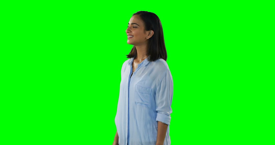 Smiling Woman in Light Blue Shirt Using Green Screen Background - Free Images, Stock Photos and Pictures on Pikwizard.com