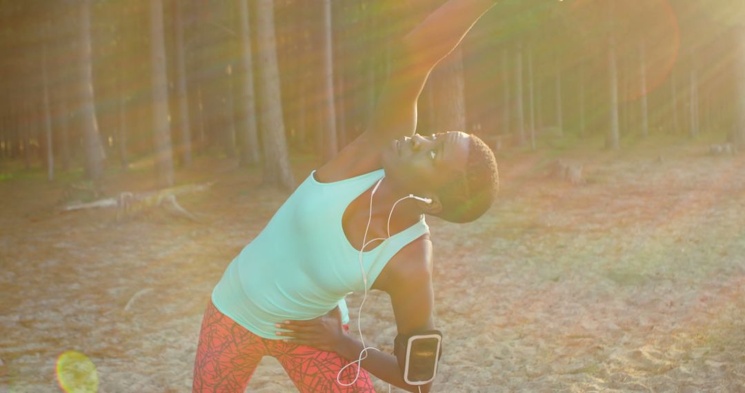 Woman Stretching in Sunlit Forest Wearing Pink Leggings and Tank Top - Free Images, Stock Photos and Pictures on Pikwizard.com