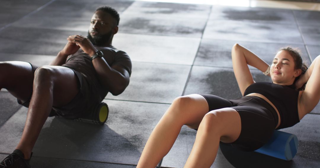 Diverse Partners Engaging in Foaming Rolling in Gym Setting