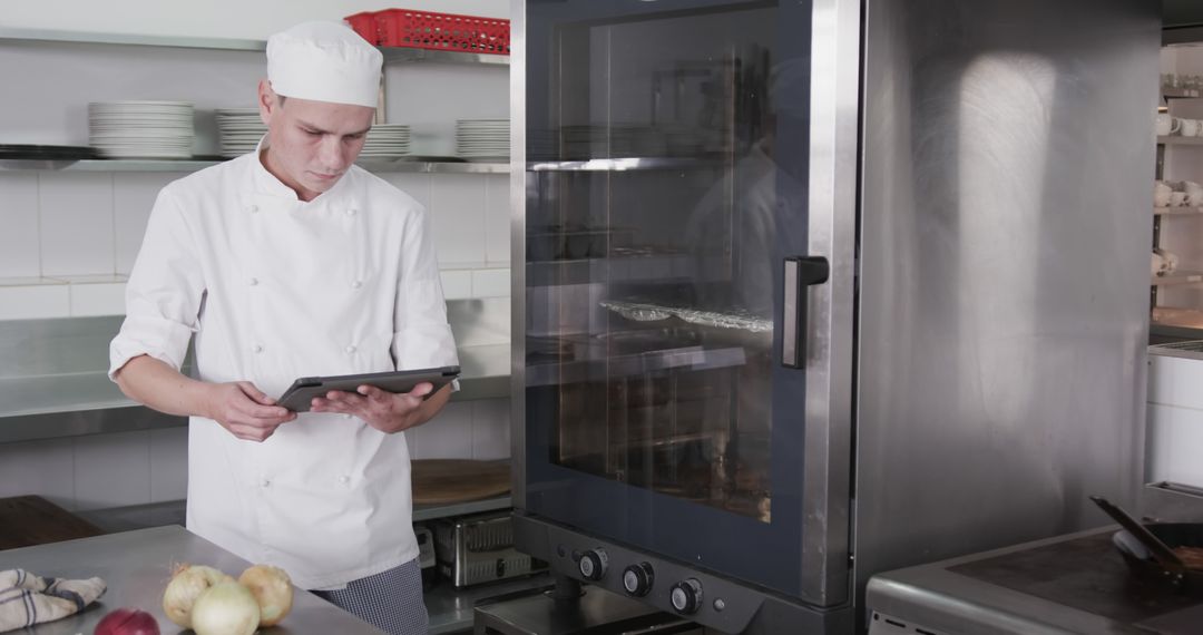 Chef in Commercial Kitchen Using Digital Tablet - Free Images, Stock Photos and Pictures on Pikwizard.com