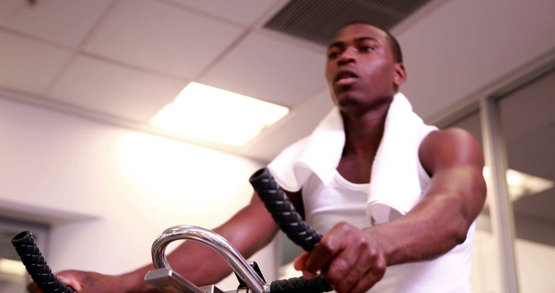 Focused man working out on exercise bike at gym - Free Images, Stock Photos and Pictures on Pikwizard.com