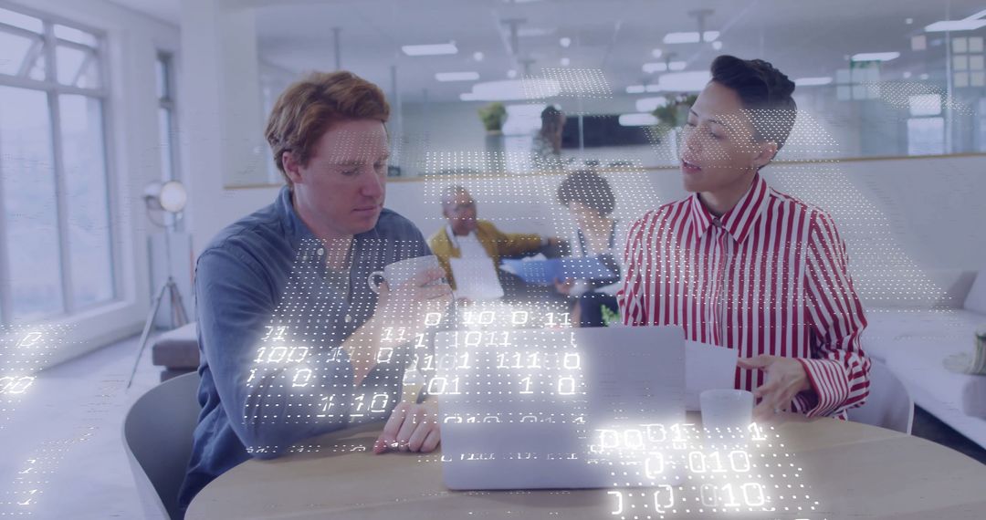 Colleagues Analyzing Data on Laptop in Contemporary Office Environment