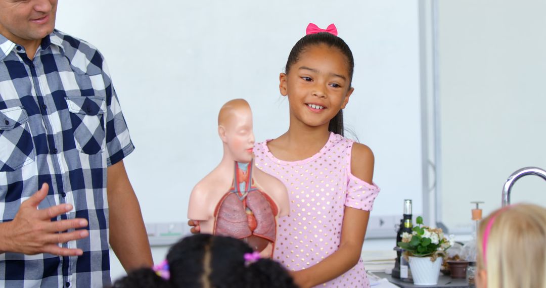 Schoolgirl Presenting Human Anatomy Model in Classroom