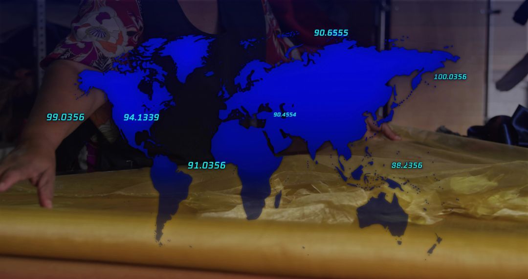Mature seamstress smoothing metallic gold fabric on worktable with blue global data overlay
