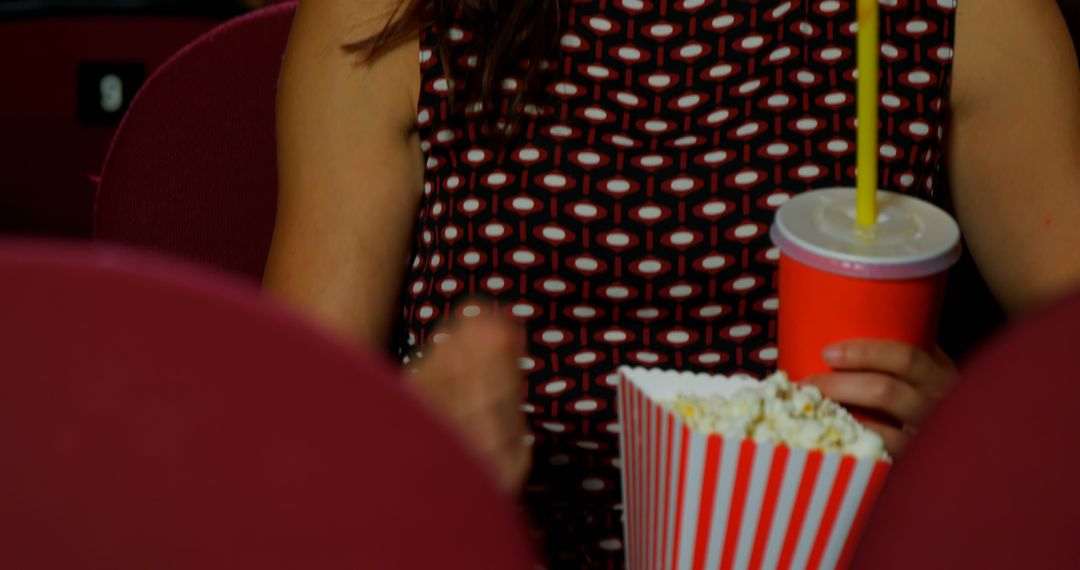 Person Holding Popcorn and Drink in Movie Theater - Free Images, Stock Photos and Pictures on Pikwizard.com