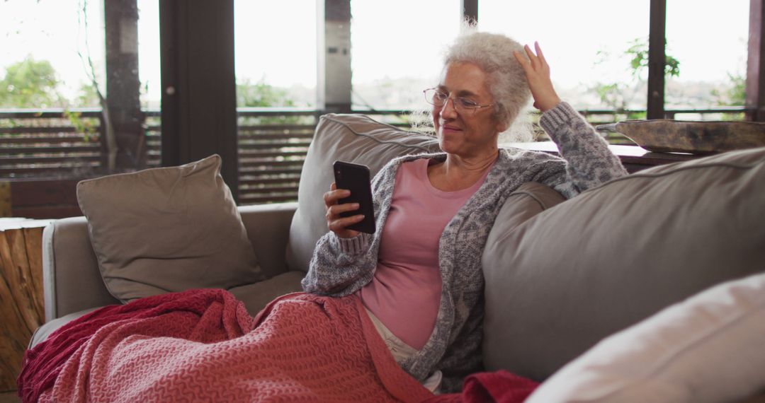 Older Adult Woman Relaxing on Couch with Smartphone - Free Images, Stock Photos and Pictures on Pikwizard.com