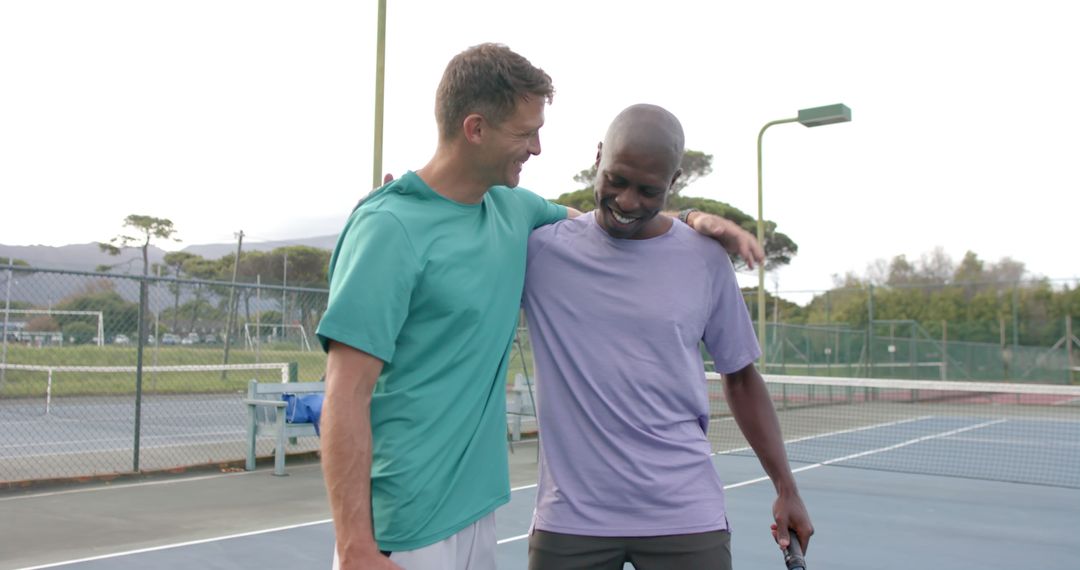 Two Friends Embracing and Smiling After Tennis Match on Outdoor Court - Free Images, Stock Photos and Pictures on Pikwizard.com