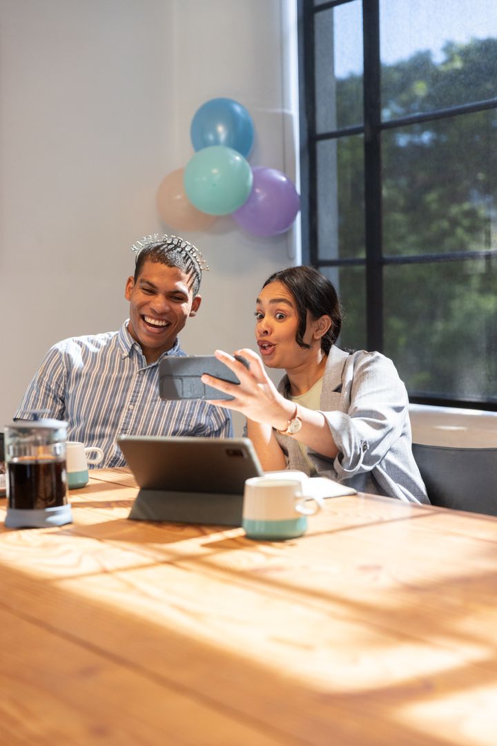 Diverse Professionals Enjoying Break with Technology at Office Table