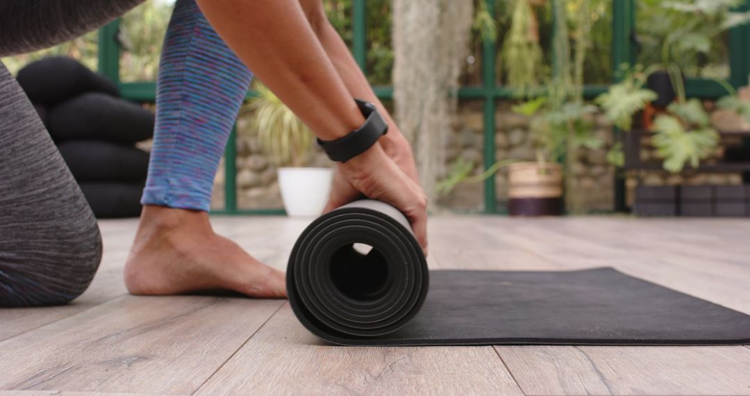 Rolling Up Yoga Mat After Outdoor Session in Garden