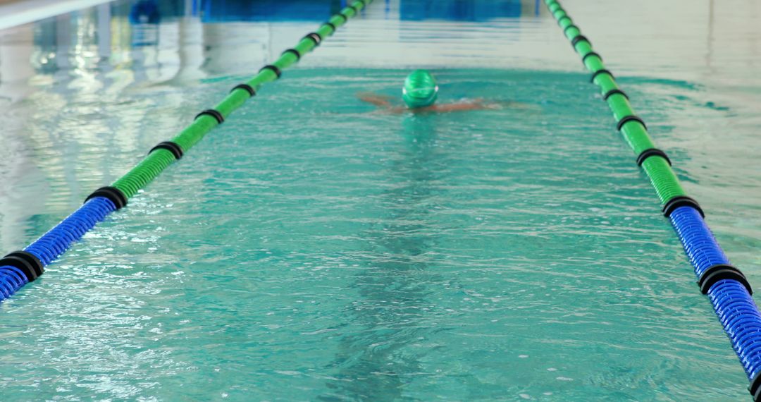 Swimmer Doing Backstroke in Indoor Pool Lane - Free Images, Stock Photos and Pictures on Pikwizard.com