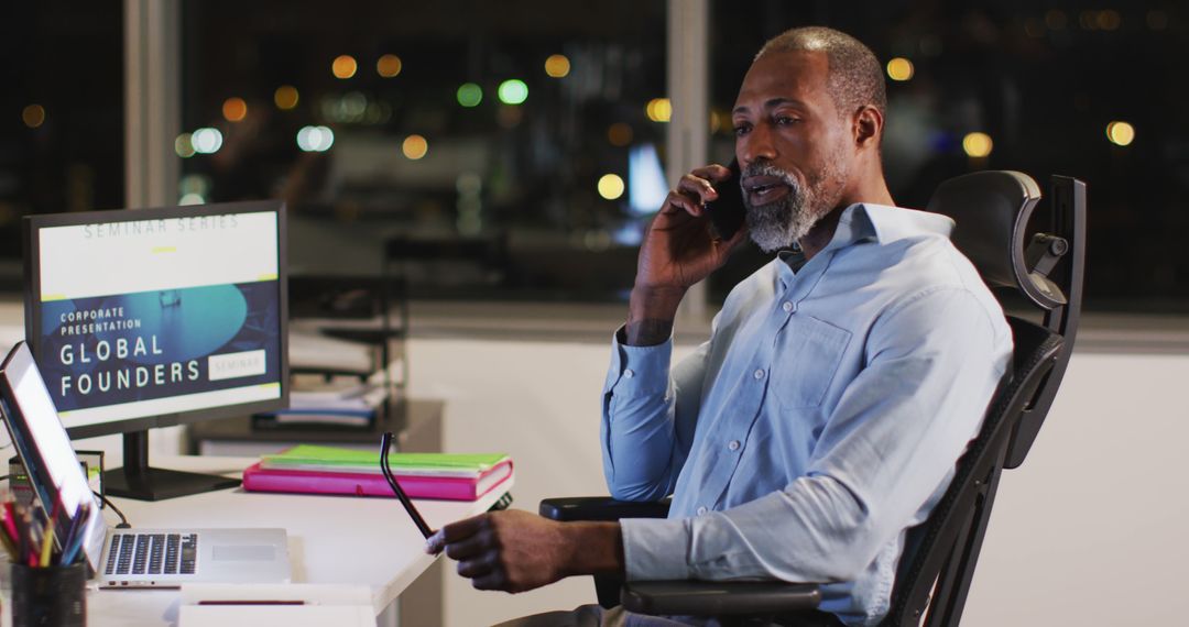 Businessman Talking on Phone in Office at Night - Free Images, Stock Photos and Pictures on Pikwizard.com