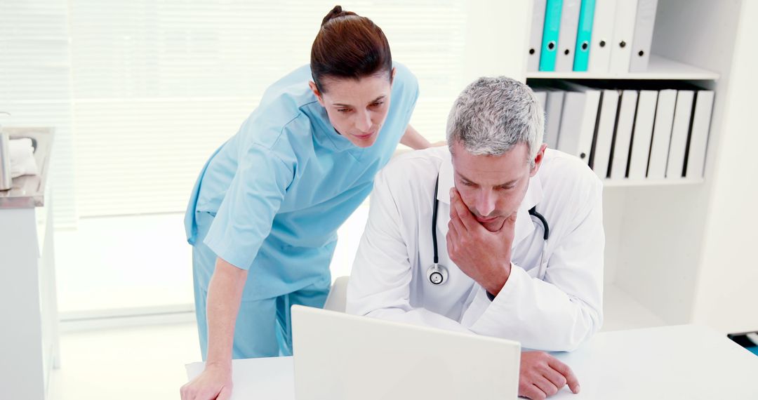 Medical Professionals Discussing Patient Data in Modern Office - Free Images, Stock Photos and Pictures on Pikwizard.com