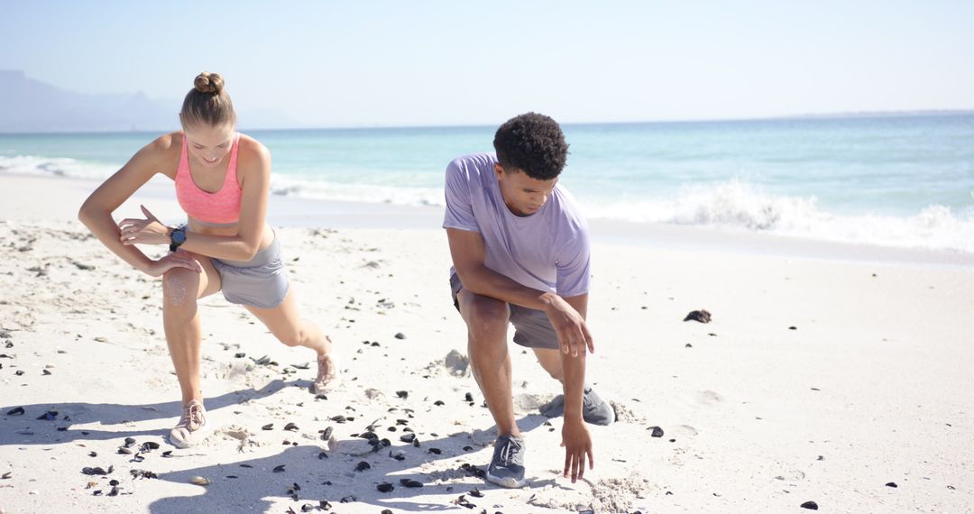 Athletic Couple Prepares for Beach Sprint Exercise on Sunny Shoreline