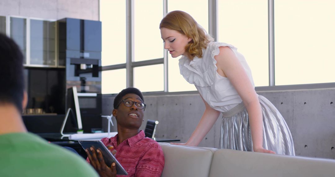 Diverse Team Collaborating on Digital Project in Modern Office Lounge
