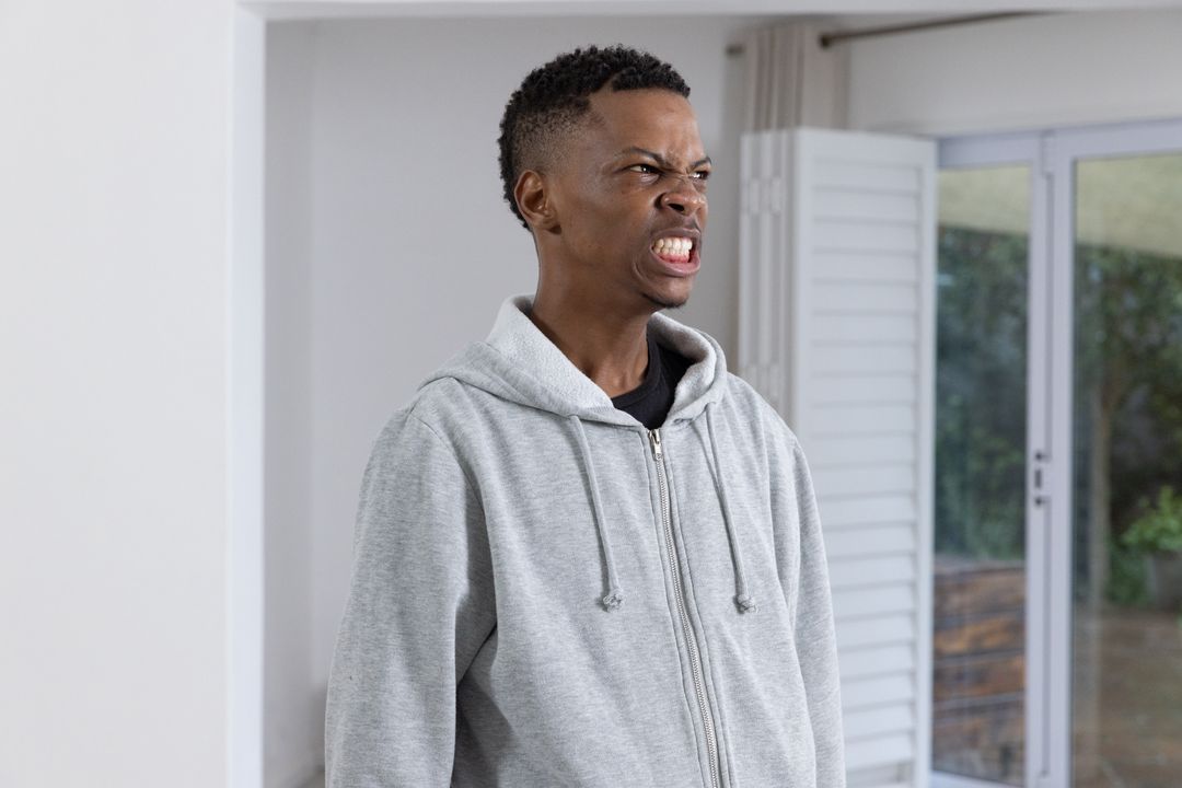 Man Grimacing Indoors in Modern Casual Wear