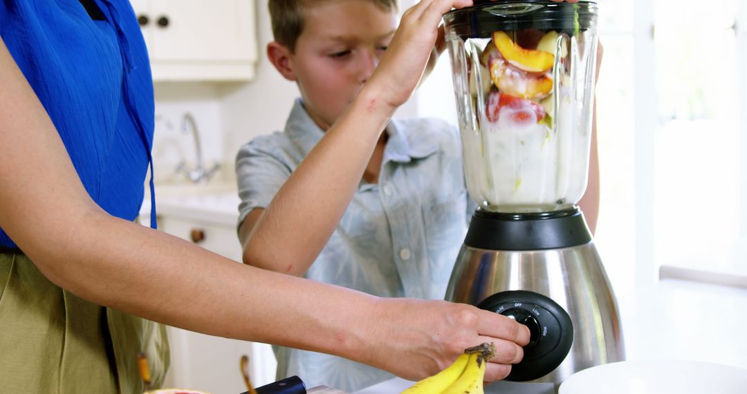 Mother and Son Making Fruit Smoothie in Kitchen - Free Images, Stock Photos and Pictures on Pikwizard.com