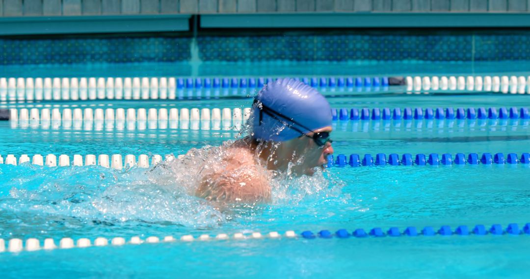 Swimmer in blue cap competing in swimming pool race - Free Images, Stock Photos and Pictures on Pikwizard.com