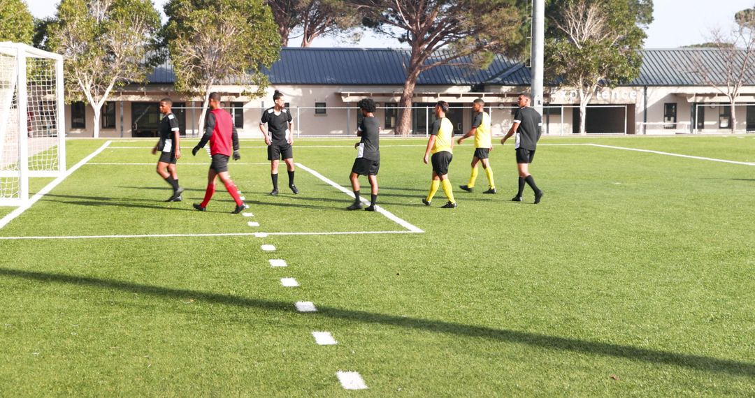 Soccer Players Strategizing on Field During Training Session