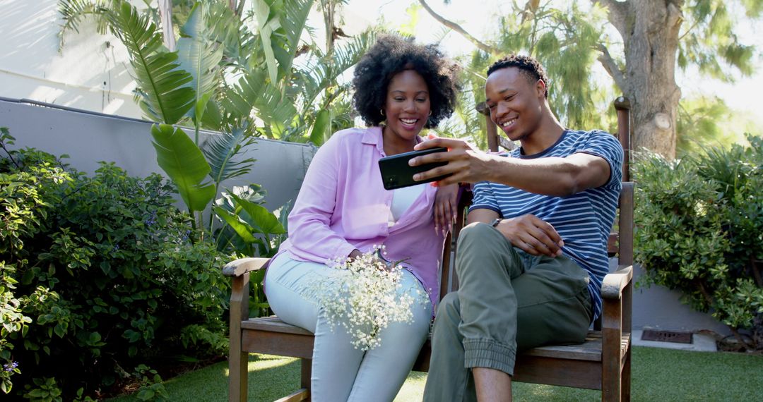 Smiling Couple Taking Selfie in Lush Garden