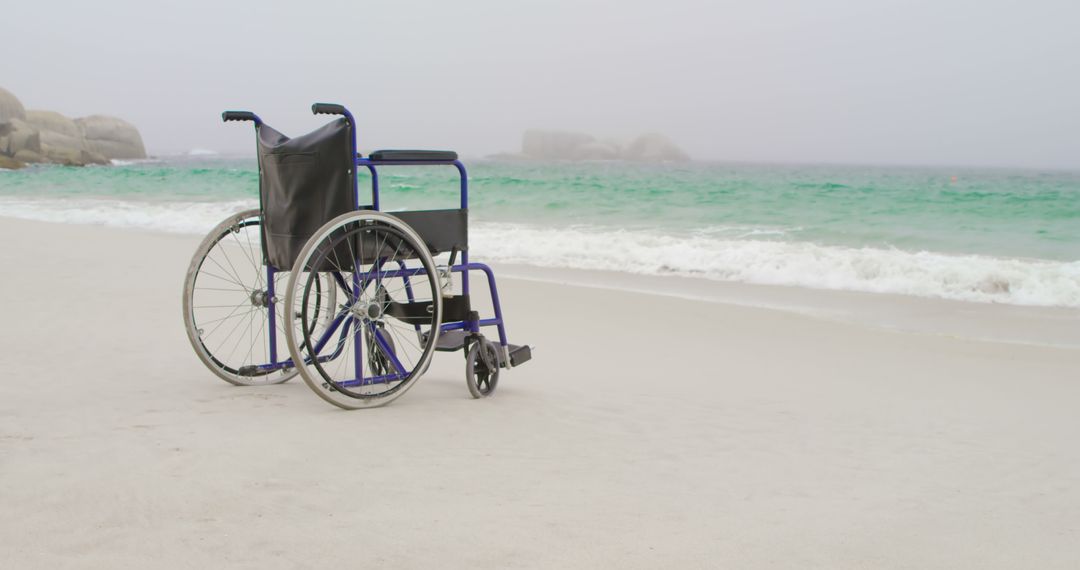 Empty wheelchair at beach on a sunny day - Free Images, Stock Photos and Pictures on Pikwizard.com