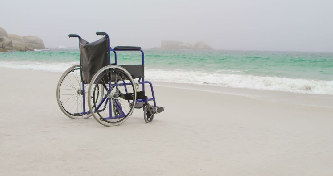 Empty Wheelchair on a Foggy Beach Near Ocean Waves - Free Images, Stock Photos and Pictures on Pikwizard.com