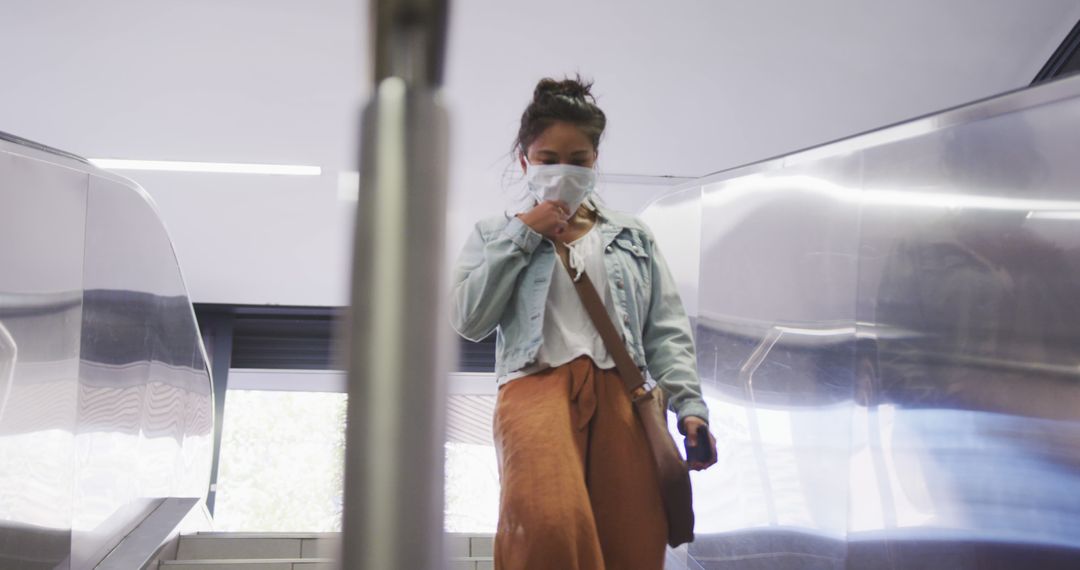 Young Woman Wearing Face Mask on Escalator During Pandemic - Free Images, Stock Photos and Pictures on Pikwizard.com