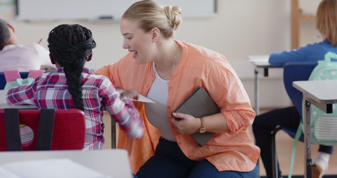 Teacher Assisting Student in Modern Classroom with Tablets