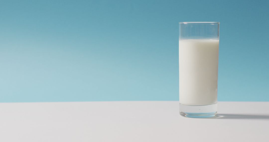 Image of glass of fresh milk over blue background - Free Images, Stock Photos and Pictures on Pikwizard.com