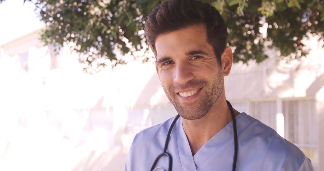 Smiling Doctor Wearing Scrubs Outdoors with Stethoscope Around Neck - Free Images, Stock Photos and Pictures on Pikwizard.com