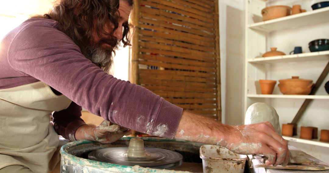 Male Pottery Artist Shaping Clay on Potter's Wheel in Workshop - Free Images, Stock Photos and Pictures on Pikwizard.com