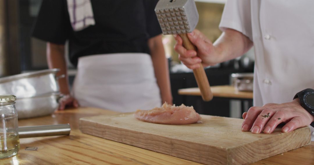 Chef Tenderizing Chicken Breast with Meat Mallet in Kitchen - Free Images, Stock Photos and Pictures on Pikwizard.com