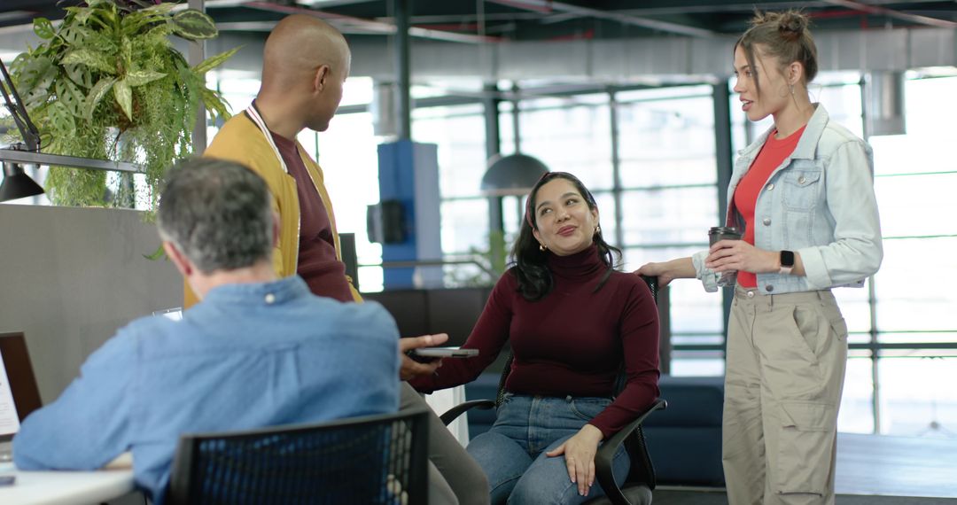 Diverse team collaborating in modern open office during casual brainstorming and coworking