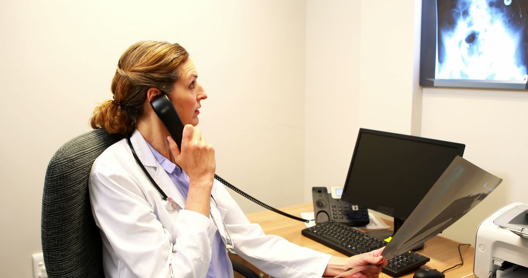 Doctor Analyzing X-Ray While Communicating on Phone in Medical Office - Free Images, Stock Photos and Pictures on Pikwizard.com